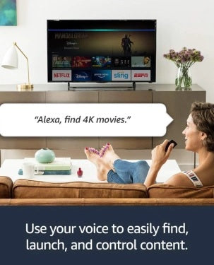 Woman using a remote control in front of a TV displaying streaming services with text 'Alexa, find 4K movies.'