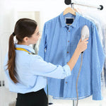 Person ironing a blue checkered shirt on a hanger