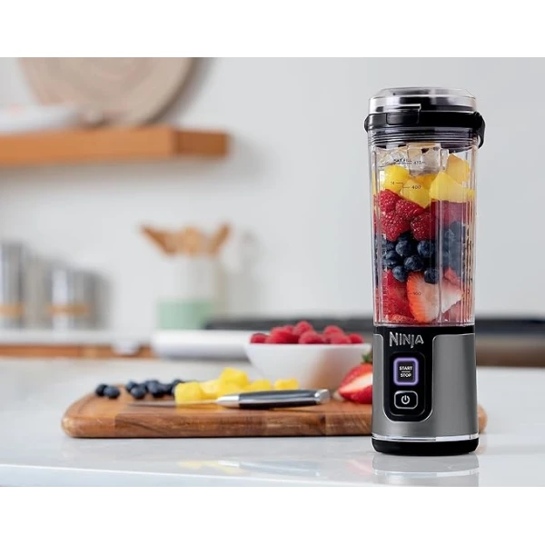 Ninja blender with fruit inside on a kitchen counter