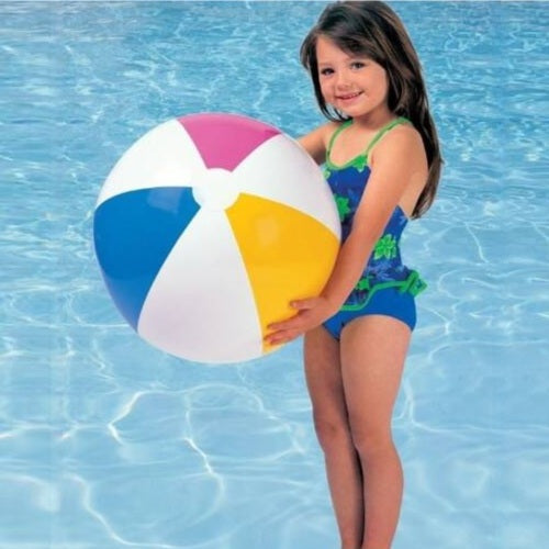 Young girl holding a colorful beach ball in a pool