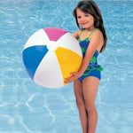 Young girl holding a colorful beach ball in a pool