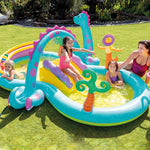 Children playing in a colorful inflatable pool with a dinosaur design on a grassy lawn.