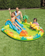 Children playing on an inflatable water play center in a grassy area.