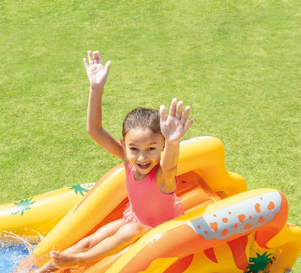 Child on a pineapple-shaped inflatable pool toy with a grassy background