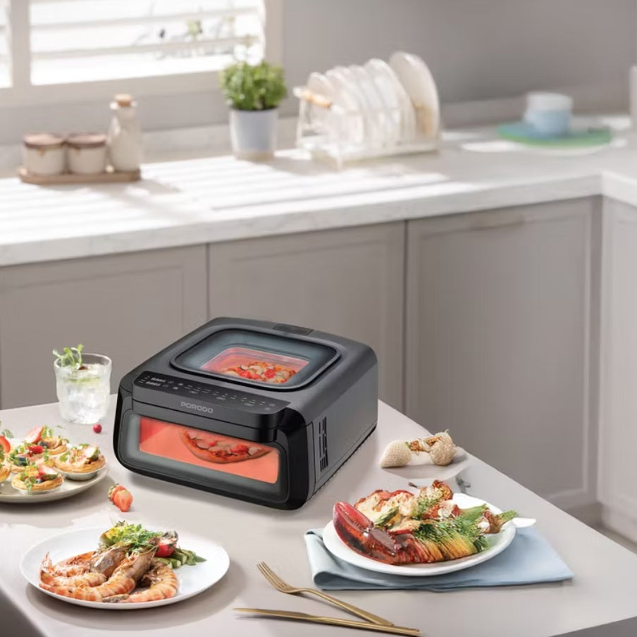 Black portable oven on a kitchen counter with food dishes around it