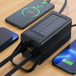 Black solar charger with multiple phone chargers on a wooden surface
