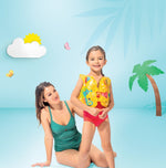 Woman and child in swimsuits with a life jacket against a tropical background
