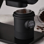 Black coffee grinder with digital display on a light gray background