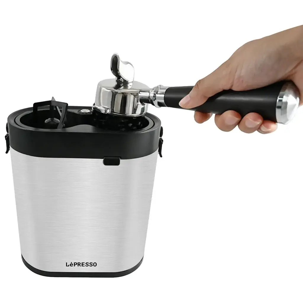 La Presso coffee maker with a hand holding a black handle on a white background