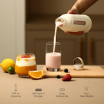 Person pouring a smoothie into a glass with a blender on a wooden cutting board, surrounded by fruits.