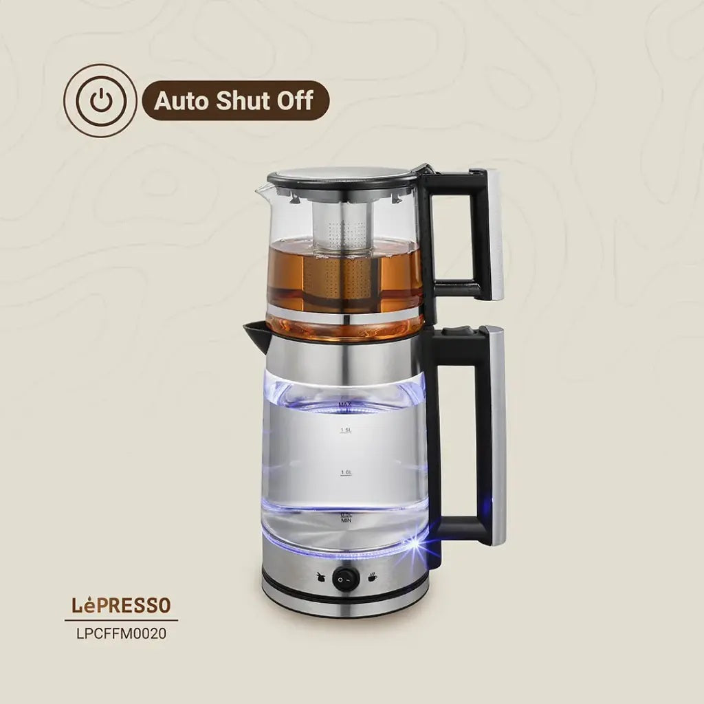 Glass coffee maker with metal base and handle, featuring 'Auto Shut Off' feature, on a beige background.