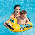 Woman and child on a yellow toy bus float in a pool
