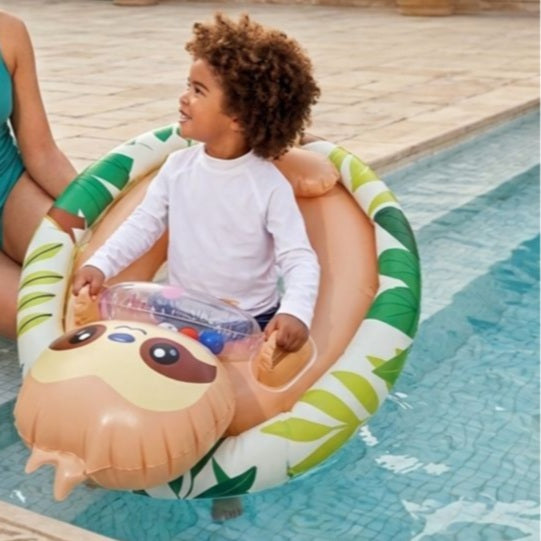 Child sitting on a sloth-themed inflatable pool float in a pool