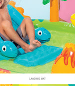 Inflatable play mat with dinosaur design on a grassy area