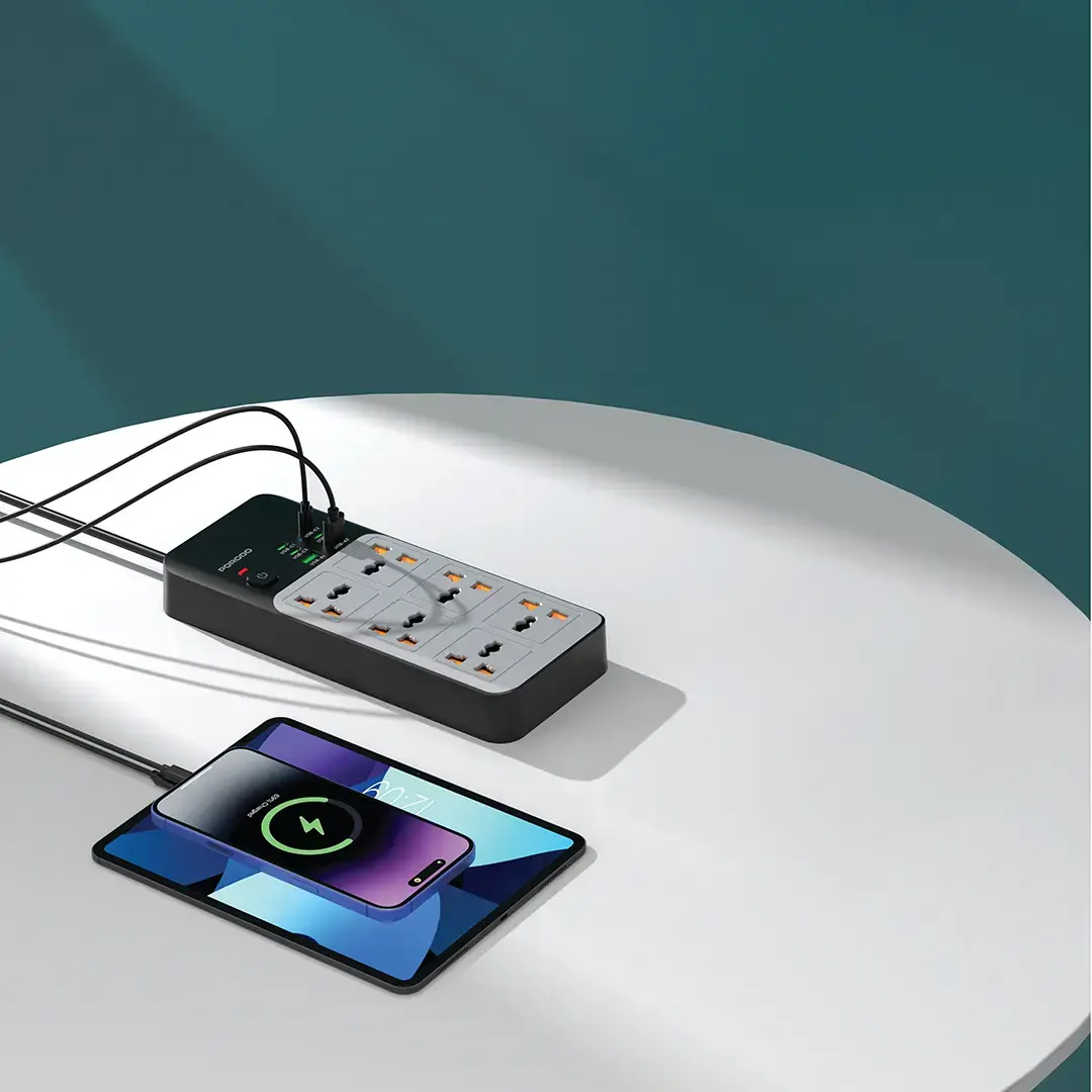 Power strip with multiple outlets and a smartphone on a white surface with a teal background