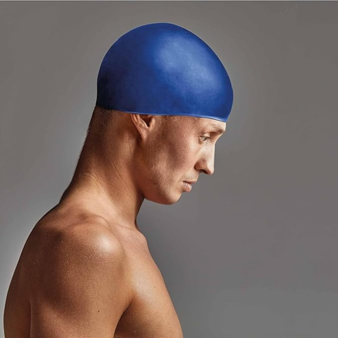 Man wearing a blue swim cap against a gray background
